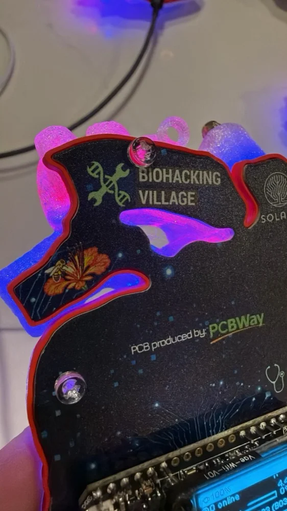 Close-up of the Heart Badge PCB showing the Biohacking Village logo and SolaSec / PCBWay branding